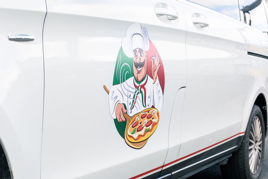 Bedruckter Freiform-Fahrzeugmagnet mit Pizzakochmotiv am weißen Van